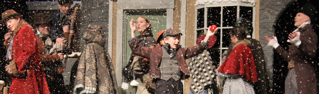 ACT II A Christmas Carol production. Shows Tiny Tim running through the village.
