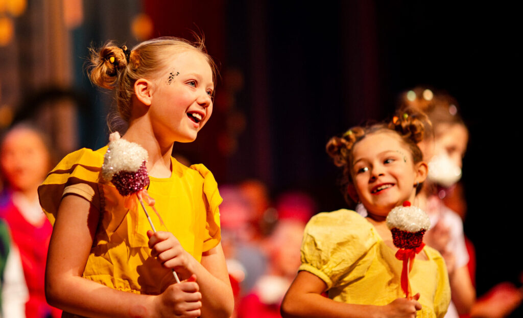 Two girls performing with candy props
